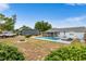 Expansive backyard features a sparkling pool, a large gray garage and mature landscaping at 100 Ellen Ct, Winter Haven, FL 33884