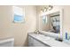 Well-lit bathroom with a vanity, window, and decorative shower curtain reflected in the mirror at 100 Ellen Ct, Winter Haven, FL 33884