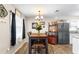 Dining area with wooden table set, bar cart with wine rack, and bright natural light from the window at 100 Ellen Ct, Winter Haven, FL 33884