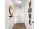 Warm, inviting entryway with wood floors and decorative HOME sign and mirror, providing a welcoming atmosphere at 100 Ellen Ct, Winter Haven, FL 33884