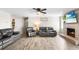 Well-lit living room with a brick fireplace, plush seating, and a ceiling fan, creating a comfortable and inviting space at 100 Ellen Ct, Winter Haven, FL 33884