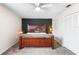 Main bedroom featuring a decorative wall, wooden bed frame, ceiling fan and carpet at 100 Ellen Ct, Winter Haven, FL 33884