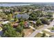 Aerial view of a home with a pool, mature trees, and a tranquil lake backdrop at 102 Lake Ring Dr, Winter Haven, FL 33884