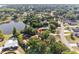 Scenic aerial view of home nestled among trees, adjacent to a serene lake at 102 Lake Ring Dr, Winter Haven, FL 33884