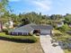 Aerial view of a beautiful home with lush trees and a lake nearby at 102 Lake Ring Dr, Winter Haven, FL 33884