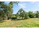 Lush backyard with mature trees and a picturesque view of the lake at 102 Lake Ring Dr, Winter Haven, FL 33884