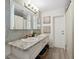 Elegant bathroom with double sinks, granite countertop, and decorative mirrors at 102 Lake Ring Dr, Winter Haven, FL 33884