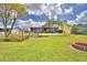 Expansive backyard with a deck, lush lawn, and an outdoor seating area perfect for entertaining at 103 Lake Thomas Dr, Winter Haven, FL 33880