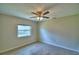 Neutral bedroom with a ceiling fan, hardwood floors and a window overlooking the outdoors at 103 Lake Thomas Dr, Winter Haven, FL 33880