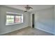 Cozy bedroom with a ceiling fan, and a view of the outside through the large window at 103 Lake Thomas Dr, Winter Haven, FL 33880
