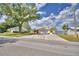 Charming home with a large driveway, lush lawn, and mature tree at 103 Lake Thomas Dr, Winter Haven, FL 33880