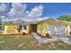 Charming single-story home with a well-manicured lawn, colorful plants, and a two-car garage at 103 Lake Thomas Dr, Winter Haven, FL 33880