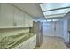 Bright kitchen featuring white cabinets, stainless appliances, and tile flooring at 103 Lake Thomas Dr, Winter Haven, FL 33880