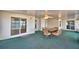 Enclosed lanai with sliding glass doors offers waterfront views and a comfortable dining area with ceiling fans at 103 Lake Thomas Dr, Winter Haven, FL 33880