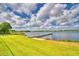 Waterfront view of a private dock on a sunny day with lush green grass in the foreground at 103 Lake Thomas Dr, Winter Haven, FL 33880