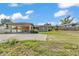 A single story home with a car port and grassy yard underneath a partly cloudy sky at 1032 Tower Blvd, Lake Wales, FL 33853