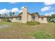 A single story home with a chimney, front yard, and grassy lawn under a partly cloudy sky at 1032 Tower Blvd, Lake Wales, FL 33853
