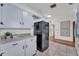 Well-lit kitchen featuring tile flooring, speckled counters, white cabinets, and a large black refrigerator at 1032 Tower Blvd, Lake Wales, FL 33853