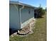 Side view of the home with a well-maintained lawn and landscaping at 11 Navel Dr, Winter Haven, FL 33884