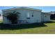 The side yard with lush green grass and blooming bougainvillea at 11 Navel Dr, Winter Haven, FL 33884