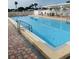Outdoor pool with lounge chairs, tables, and a shaded area on the deck for residents at 11 Navel Dr, Winter Haven, FL 33884