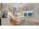 Well-lit bedroom showcasing decorative bedding, hardwood floors, and a large window at 1162 E Highland Dr, Lakeland, FL 33813