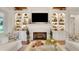 Stylish living room featuring a fireplace, custom built-ins, and comfortable white couches at 1162 E Highland Dr, Lakeland, FL 33813
