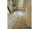 Kitchen featuring outdated appliances, white cabinets, tile flooring, and a window providing natural light at 128 11Th Wahneta W St, Winter Haven, FL 33880