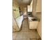 Galley kitchen featuring dated white appliances, including a refrigerator and stove, alongside a double-basin sink at 128 11Th Wahneta W St, Winter Haven, FL 33880