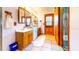 Dual vanity bathroom with wood cabinets and a large mirror above each sink with a tiled floor at 1432 Libby Rd, Babson Park, FL 33827