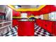 Bright kitchen features red cabinets, black countertops, stainless steel appliances and checkered floors at 1432 Libby Rd, Babson Park, FL 33827