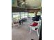 Bright sunroom featuring classic wicker chairs, carpeted flooring, and large windows offering serene views at 148 Sweet Cir, Winter Haven, FL 33884