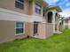 Condo exterior featuring neutral-colored stucco, sliding door to patio, and manicured lawn at 1503 Eagle Pond Dr # 1503, Winter Haven, FL 33884