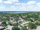 An elevated neighborhood view featuring tree-lined streets with rooftops scattered among the canopy, and a lake in the distance at 1506 Chamberlain Loop, Lake Wales, FL 33853