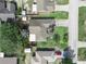 Overhead drone shot reveals the roof, driveway, and manicured lawn surrounded by lush greenery and neighboring properties at 1506 Chamberlain Loop, Lake Wales, FL 33853