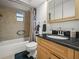 Bathroom featuring a tub with shower, and a wood vanity with black countertop and integrated sink at 1506 Chamberlain Loop, Lake Wales, FL 33853