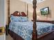 Bedroom features a four-poster bed with blue patterned bedding and matching dresser at 1506 Chamberlain Loop, Lake Wales, FL 33853
