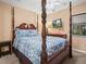 Bedroom showcases a four-poster bed with patterned bedding, ceiling fan, and wall-mounted television at 1506 Chamberlain Loop, Lake Wales, FL 33853