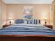 Bedroom with matching lamps, blue pillows, and wooden furniture at 1506 Chamberlain Loop, Lake Wales, FL 33853
