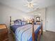 Bedroom with four-poster bed with blue and white bedding, mirrored closet, and ceiling fan with lighting at 1506 Chamberlain Loop, Lake Wales, FL 33853