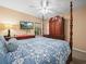 Bedroom featuring a four-poster bed with blue bedding, dresser, mounted TV, and ceiling fan at 1506 Chamberlain Loop, Lake Wales, FL 33853