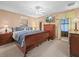 Bedroom with four poster bed, ceiling fan, mounted TV, and yellow drapes at 1506 Chamberlain Loop, Lake Wales, FL 33853