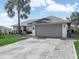 Inviting single-story home with an attached two-car garage and a well-maintained lawn on a sunny day at 1506 Chamberlain Loop, Lake Wales, FL 33853