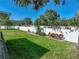Backyard with healthy green grass, a white fence, landscaping, and covered patio at 1531 Oakview Se Cir, Winter Haven, FL 33880