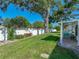Backyard with healthy green grass, a white fence, landscaping, and covered patio at 1531 Oakview Se Cir, Winter Haven, FL 33880