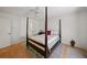 Well-lit bedroom with a four-poster bed, wood floors, and neutral colors creating a relaxing space at 1531 Oakview Se Cir, Winter Haven, FL 33880
