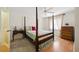 Cozy bedroom featuring a four-poster bed, wood flooring, natural light, and traditional decor at 1531 Oakview Se Cir, Winter Haven, FL 33880