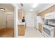 Well-lit kitchen showcasing ample storage, natural wood cabinetry, and easy access to the entryway at 1531 Oakview Se Cir, Winter Haven, FL 33880