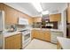 Cozy kitchen with essential appliances, wooden cabinets, and a bright window over the sink at 1531 Oakview Se Cir, Winter Haven, FL 33880