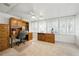 Home office with wooden desk, cabinets, ceiling fan, and large windows at 1531 Oakview Se Cir, Winter Haven, FL 33880